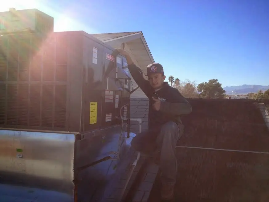 HVAC technician performing AC Tune-Up on a rooftop unit in Port Orange